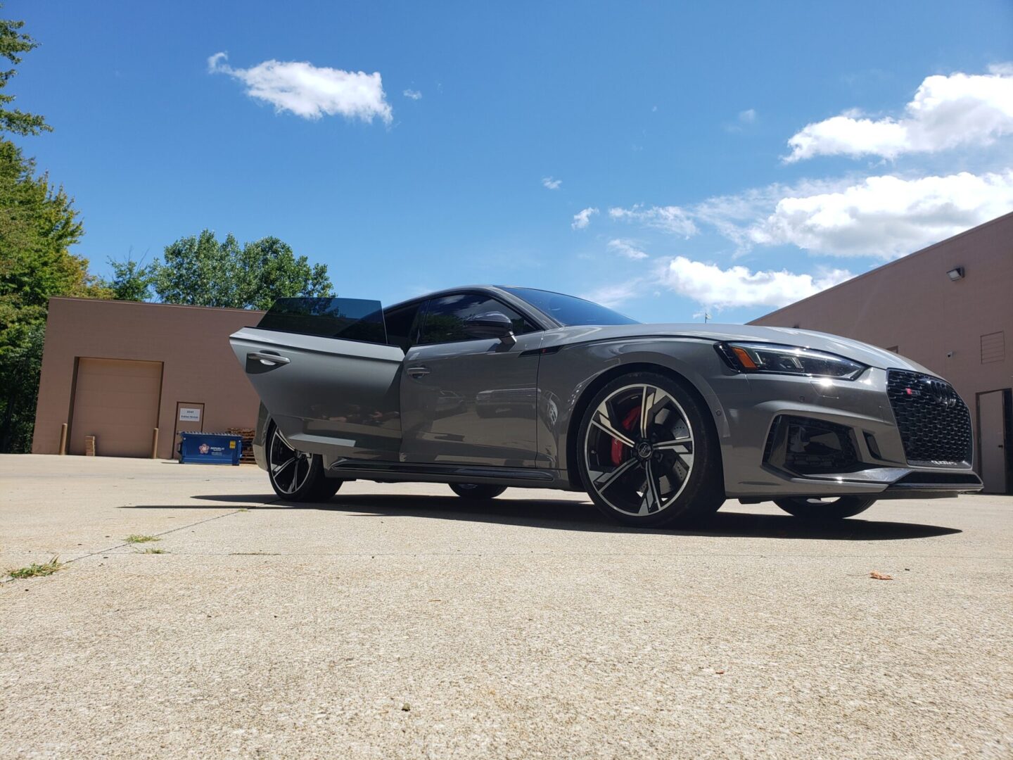 Sporty gray car parked outside a building.