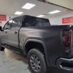 Black pickup truck in window tinting shop.