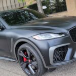 Matte black SUV parked near building.