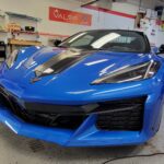 Blue sports car in a garage setting.