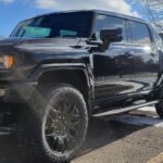 Black pickup truck parked on snowy pavement.