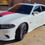 White sports car parked on concrete driveway.