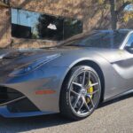 Gray sports car parked in sunlight.