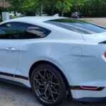 White sports car parked in a lot.