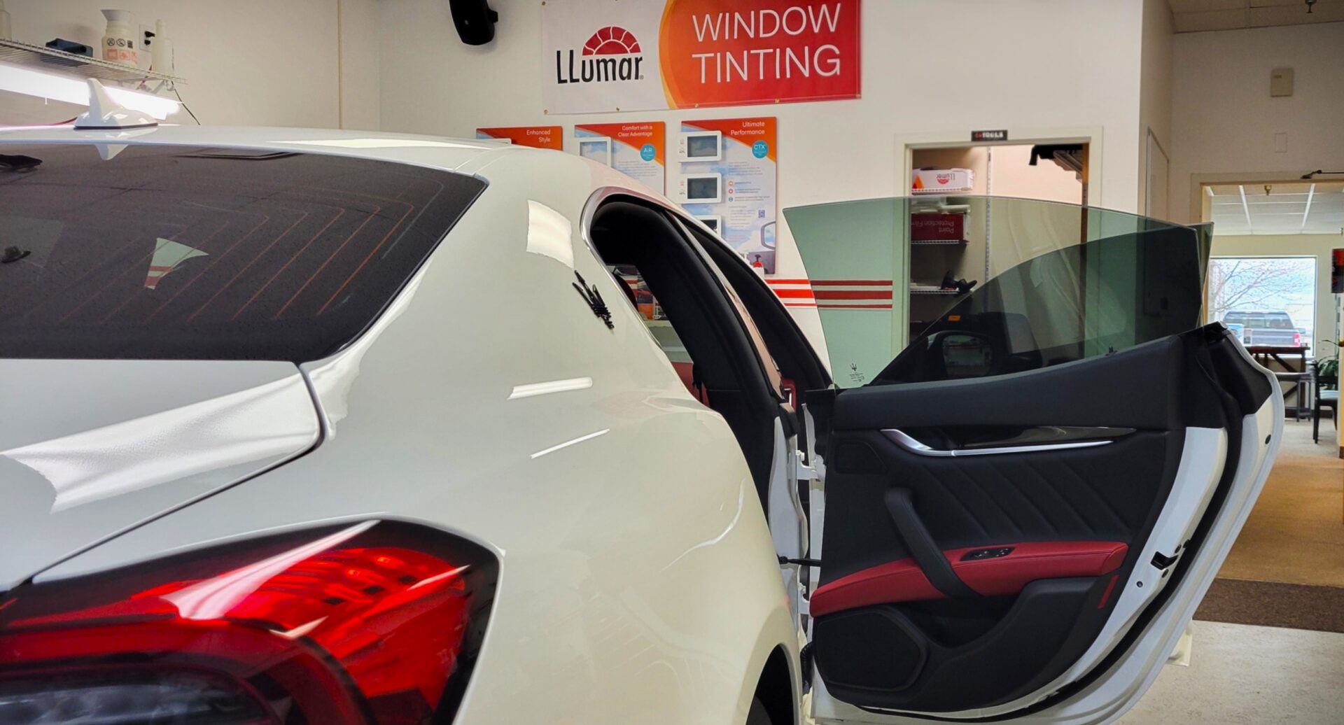 Car with open door in tinting shop.